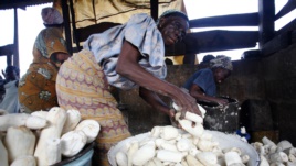 Women work in a cassava grinding mill in Nigeria.