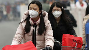 Girls wearing masks ride bicycles amid the heavy haze in Beijing February 22, 2014.